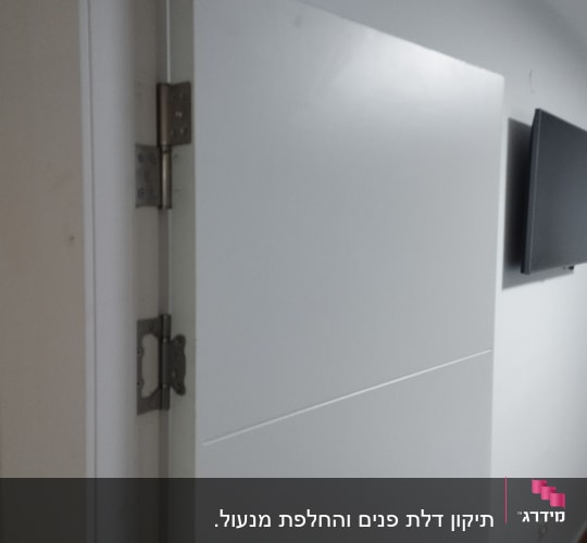 דלת לבנה עם צירים וקיר לבן